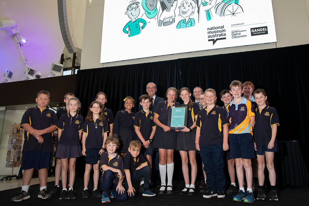 Students from Binalong Primary School, New South Wales, receive their History Makers 2022 prize from Steven Gandel and National Museum Director, Dr Mathew Trinca. 