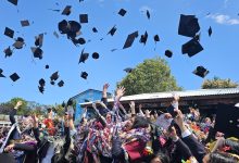 Graduating students throw hats in the air